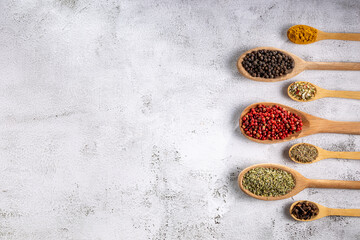 Various spices and seasonings in wooden spoons.