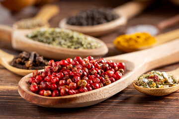 Various spices and seasonings in wooden spoons.