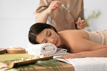 Obraz na płótnie Canvas Pretty young Asian woman relaxing in spa salon