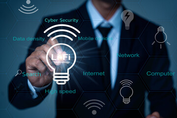 An IT professional in a black suit touches the Lifi symbol in a hexagonal grid surrounded by words...