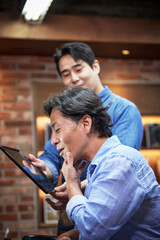 바버샵에서 면도 후 손으로 턱을 만지며 흡족한 표정을 짓고있는 고객