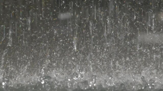 waterdrops falling in slow motion medium close-up, heavy rain raindrops splashing, gushing water in slomo, water droplets crashing down.