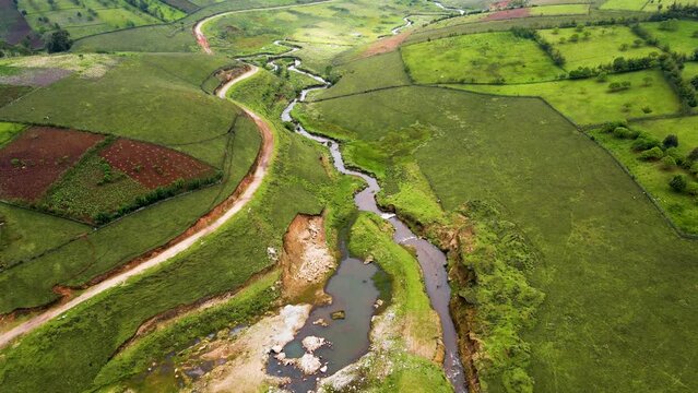 Climate change concept cop Kenya. Birdseye aerial view of Africa Kenya, shanty poor neighborhood of West pokot, Kenya. Low populated area with water stream, top down drone shot.