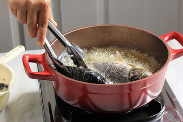 Process of Frying River Carp Fish in a Red Frying Pan.