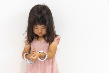 玩具の手錠をはめた女の子（日本人、３歳）
