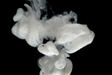 Abstract paint splash isolated on black background. Acrylic ink in water. selective focus.