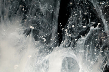 Abstract paint splash isolated on black background. Acrylic ink in water. selective focus.