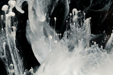 Abstract paint splash isolated on black background. Acrylic ink in water. selective focus.