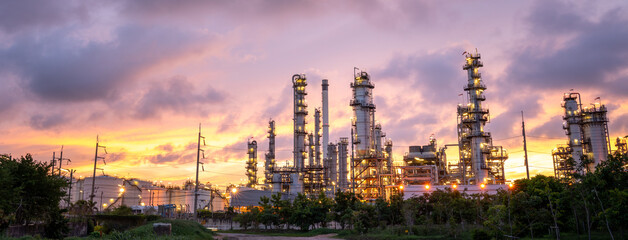 Naklejka premium Oil Refinery Plant at sunset. Gas Chemical Equipment Prodiction import export Concept, Crude Oil Refinery Plant Steel Pump Pipe line and Chimney and Cooling tower, Chemical or Petrochemical plant
