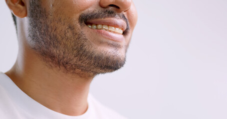 A man checking his beard while standing in front of mirror in bathroom at home.