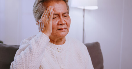 Asian old woman with migraine headache. Elderly woman suffering from a headache.