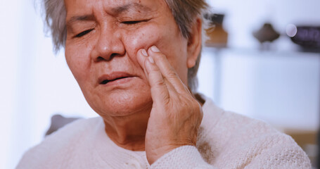 Asian elderly woman suffering from toothache.