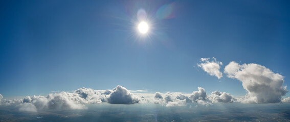 Aerial view from airplane window at high altitude of earth covered with puffy cumulus clouds...