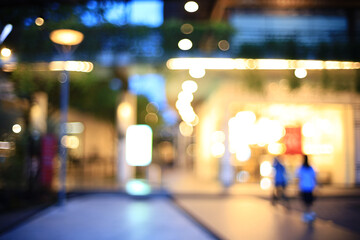 abstract blur outdoor shopping avenue at twilight for background, customers walk on boardwalk