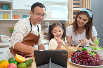 Asian family enjoy making a vegetable salad together.