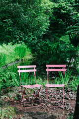 Pink chairs in the garden in summer.