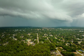 Obraz premium Landscape of dark ominous clouds forming on stormy sky before heavy thunderstorm over rural town area