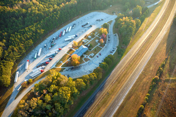 Large truck stop with resting area near busy american interstate freeway with fast driving cars and trucks. Recreational parking place during interstate travel