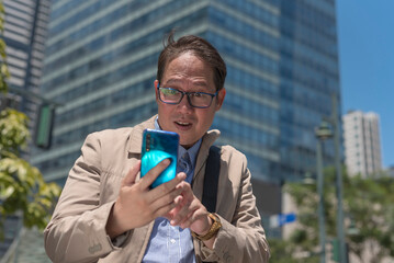 A man upon checking the time on his smart phone realizes that he is late for his appointment or...