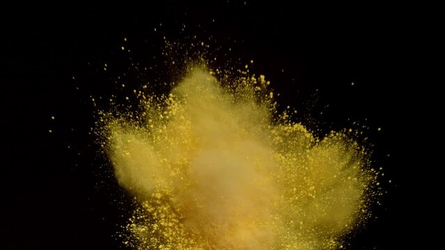 yellow powder,Powder exploding against black background. Shot with high speed camera, Slow Motion.