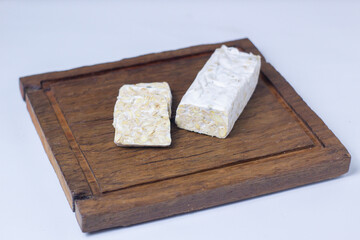 Sliced ​​Raw Tempeh on a wooden cutting board. Vegetable protein.
