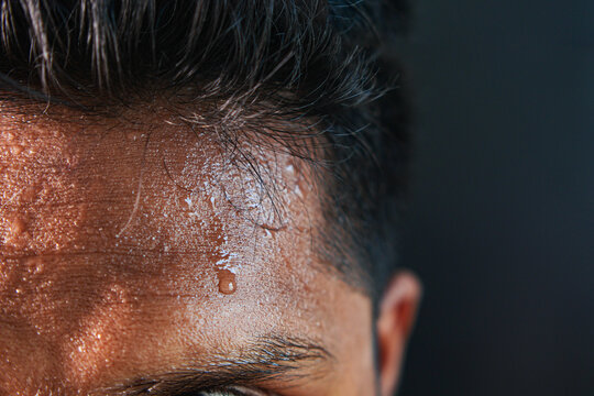 closeup of sweat on forehead against dark background ,