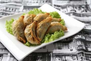 deep fried pork chicken dumpling guo tie jiaozi dim sum in plate on grey vintage building...