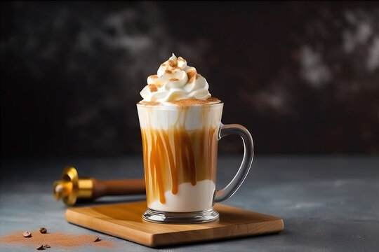 Iced caramel latte topped with whipped cream and caramel sauce, refreshing and sweet coffee drink. Dark background. 