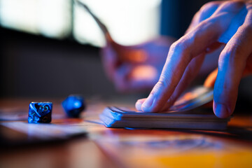 A man drawing trading card game from a deck on a table