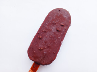 Chocolate ice cream with almonds on a stick on a white background
