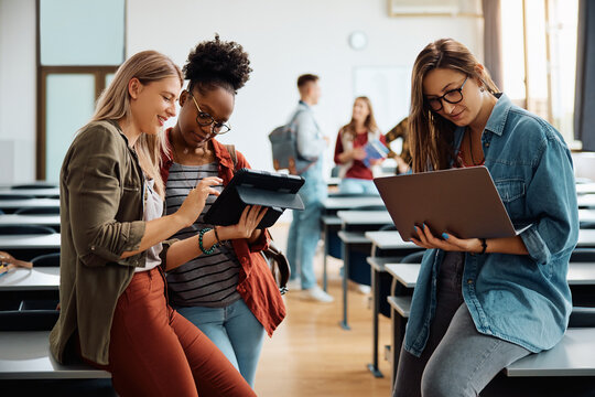 Female students e-learning while using wireless technology at university classroom.