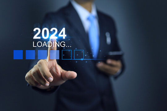 Businessman holding smart phone and touching on loading for new year 2024 to start the business planing and goal with action plan strategy for chalange revenue target