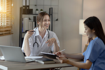 Two female doctor working at desk in clinic office, Teamwork in medicine and healthcare concept.	