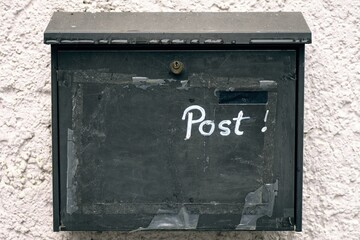 Old mailbox on the wall with inscription Post. 