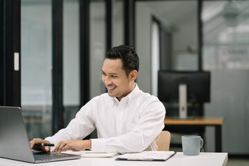 Business man working at office with laptop and documents on his desk, financial adviser analyzing data.