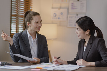 Group of businesswoman team working with analysis financial data visualization tech for marketing strategy, Businesswoman accountant or financial report graph at desk in corporate office.