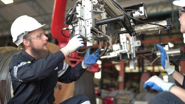 Mechanical engineers with robotic welder., Programming development technology work. industrial engineer working at automated AI robotic production factory.