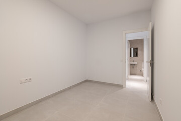 Empty white room with an open door - access to the bathroom. The concept of selling housing in a new building or an apartment after renovation