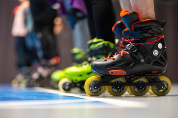 Close-up of roller skates of people training figure skating in a sports hall. Photo taken with...