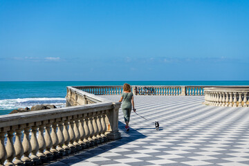 woman with dog on the Terrazza Mascagni in Livorno, italy