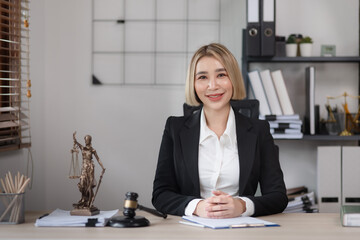 Law and Justice concept, Female lawyer and discussing contract papers with brass scale at desk in office, Law, legal judgement.