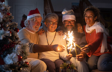 Lovely family group of senior parents and middle aged son with wife celebrating together Christmas holidays and new year with sparkling lights.