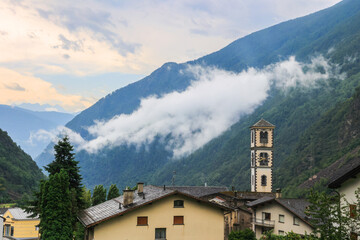 Tower of the Catholic church of San Carlo Borromeo in the Swiss town Brusio in the morning with fog...