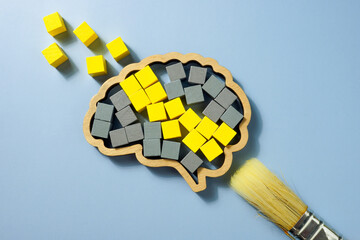 A Brush, brain shape with yellow and gray cubes. Cognitive Behavioral Therapy CBT concept.