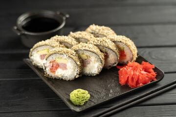 Hot fried Sushi Roll with tuna, avocado and cheese Philadelphia, soy sauce and wasabi on table. Sushi menu. Japanese food. Futomaki