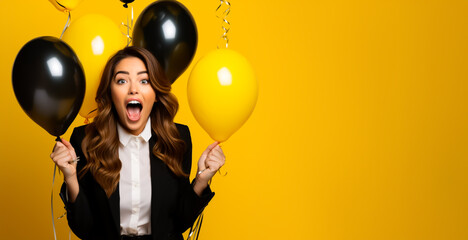 Amazed Woman with black and yellow Balloons on a yellow background. Black Friday or Cyber Monday...