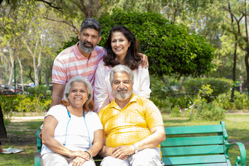 Indian family giving happy expression at park.