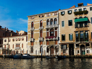 Fototapeta na wymiar Old and historical Venetian houses with canal waterfront landscape and moored modern boats in Venice Italy