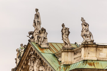 Classical statues on the rooftop of a building