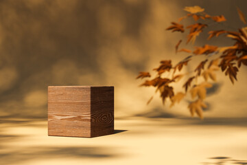 Cube shaped wooden side table on surface with autumn leaves in light